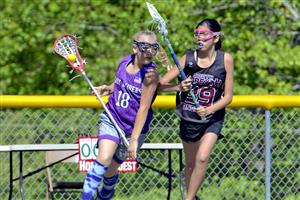Two girls competing during a lacrosse game